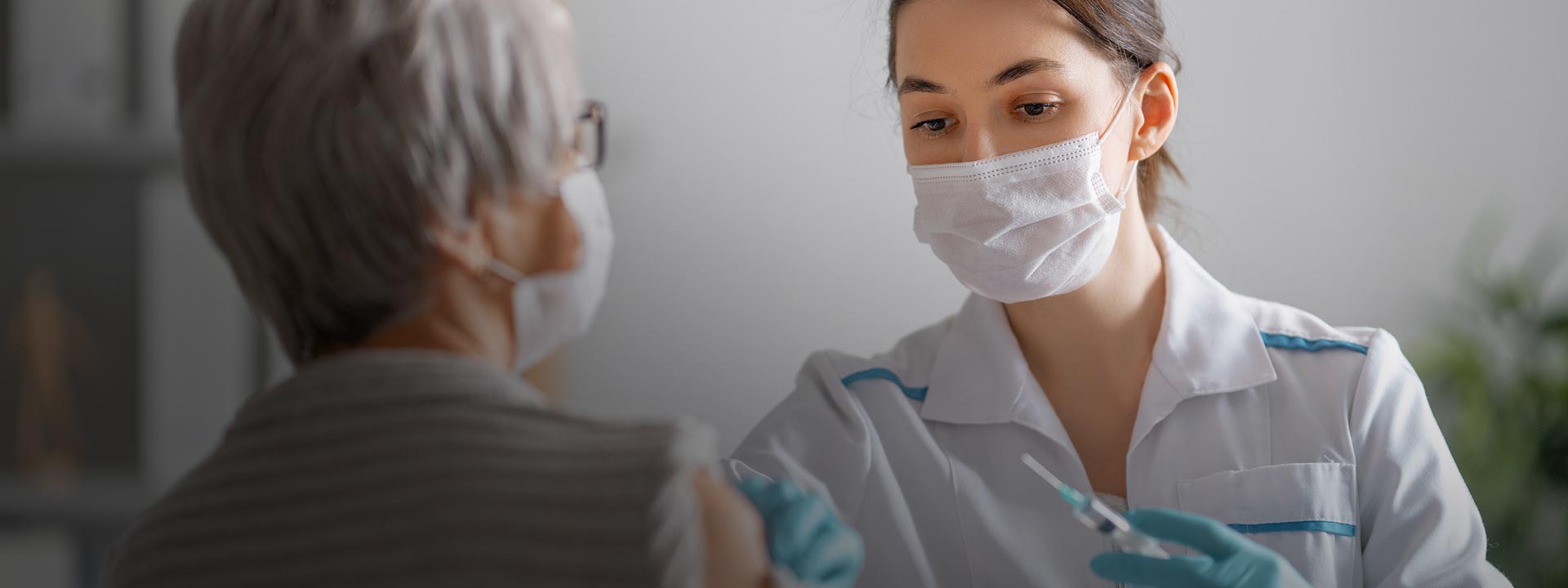 Une infirmière administre un vaccin à une patiente.
