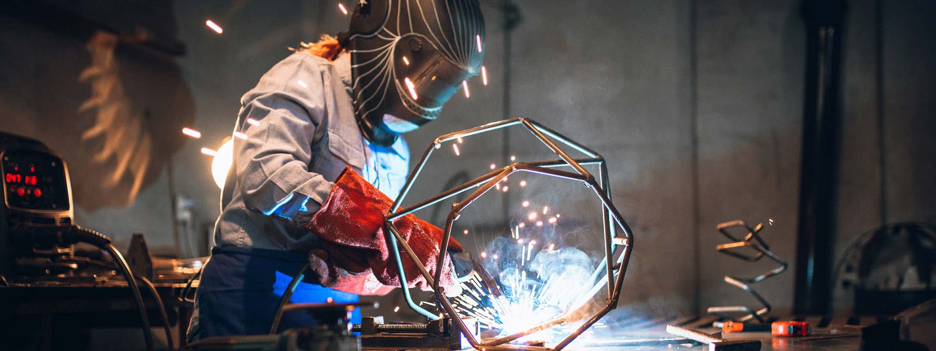 Une étudiante procède au soudage de pièces de métal dans un atelier.