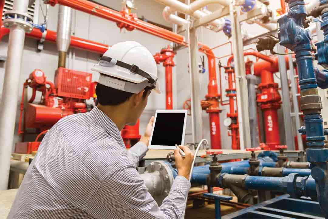 Un technicien utilise un appareil électronique dans une salle de contrôle.