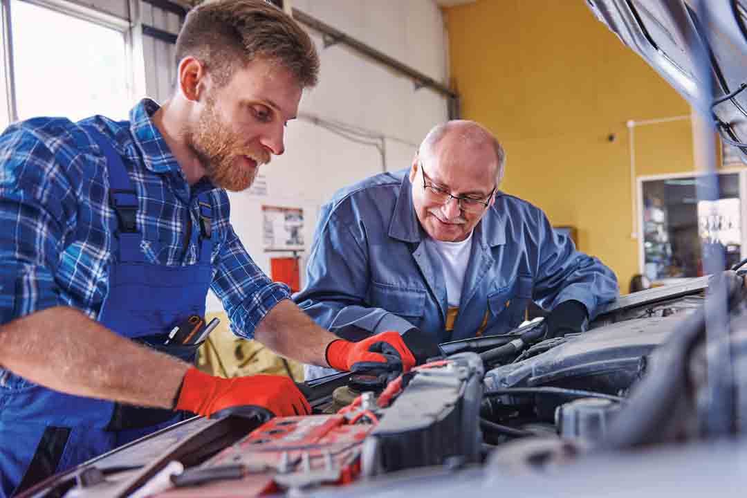 Deux techniciens effectuent un diagnostic sur une voiture.