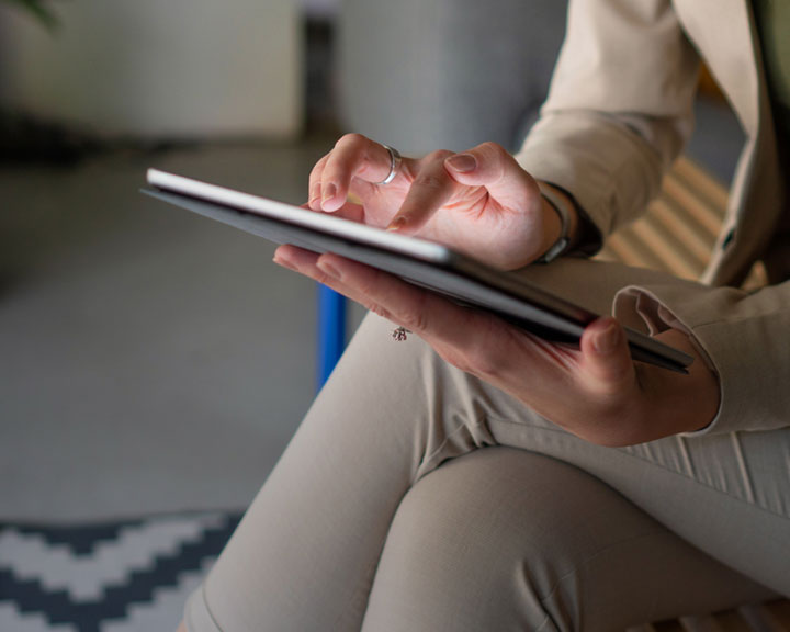 Une femme consulte des documents à l'aide d'une tablette électronique.