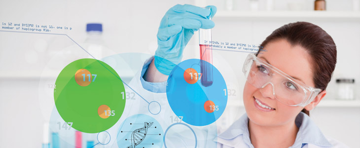 Une étudiante en laboratoire examine une éprouvette contenant un liquide rouge.