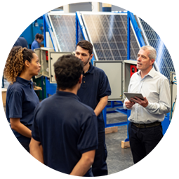  Un enseignant répond à une question d'un élève devant des panneaux photovoltaïques