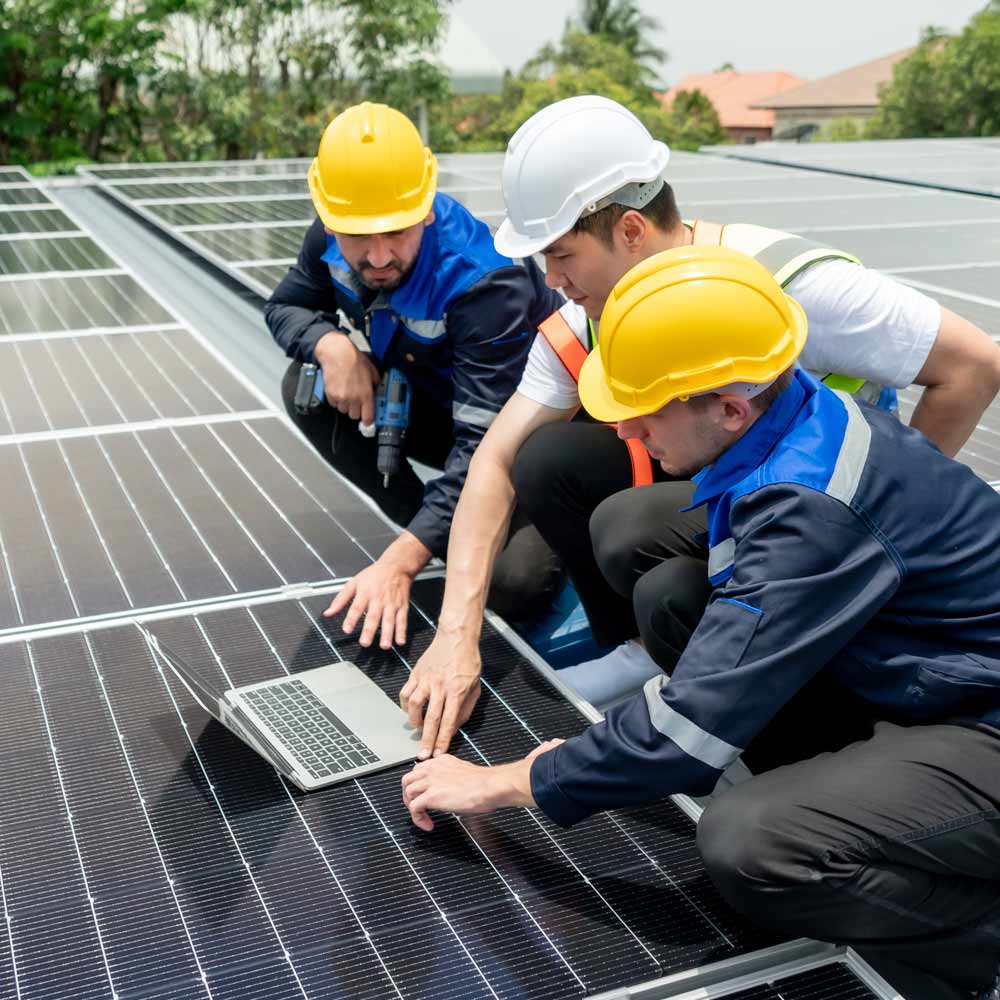 Groupe de jeunes ingénieurs chargés de la maintenance du système de panneaux photovoltaïques.