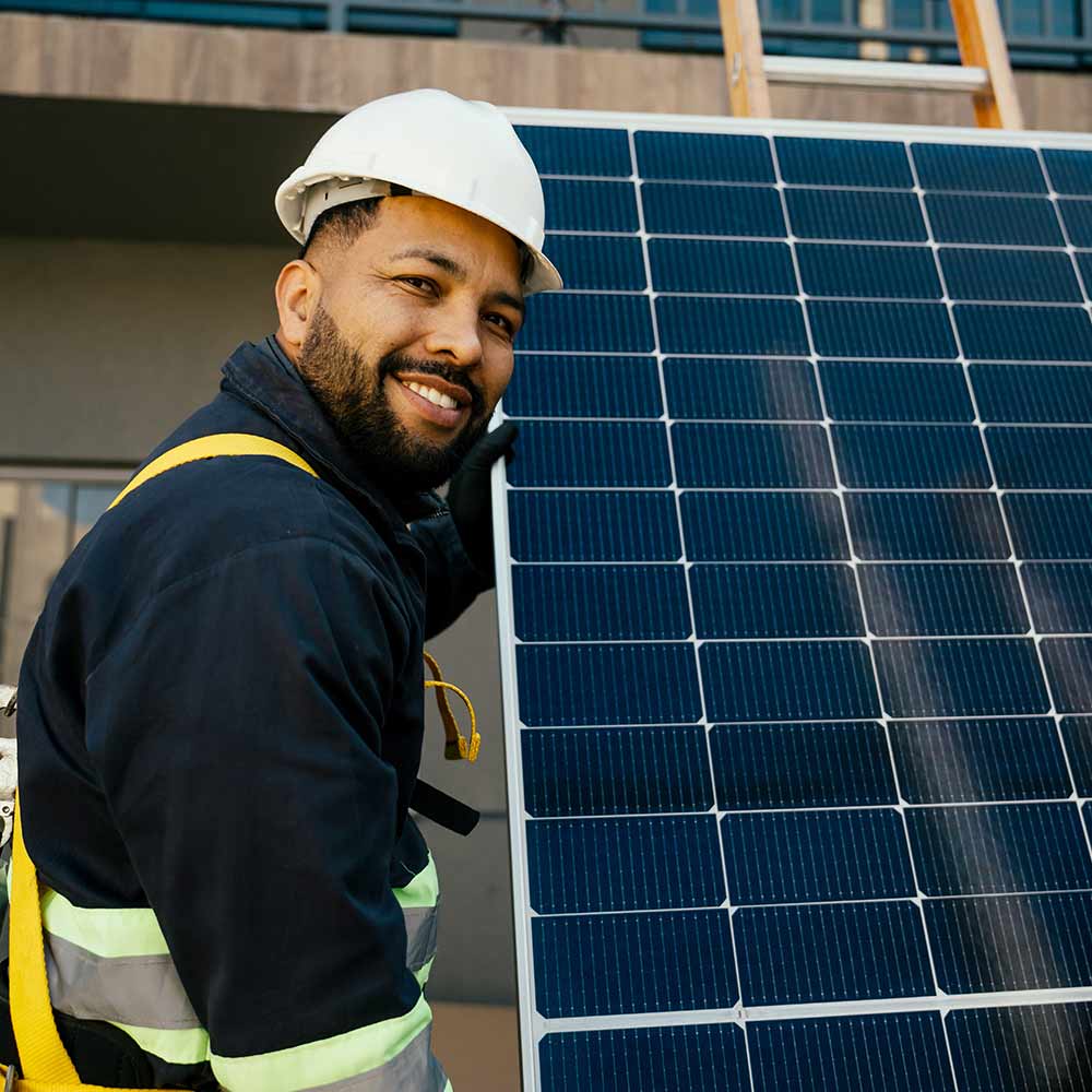 Un ouvrier tient un panneau solaire pour commencer l'installation