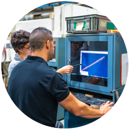 Rear view of a female manager and engineer using computer in a cnc metallurgic factory