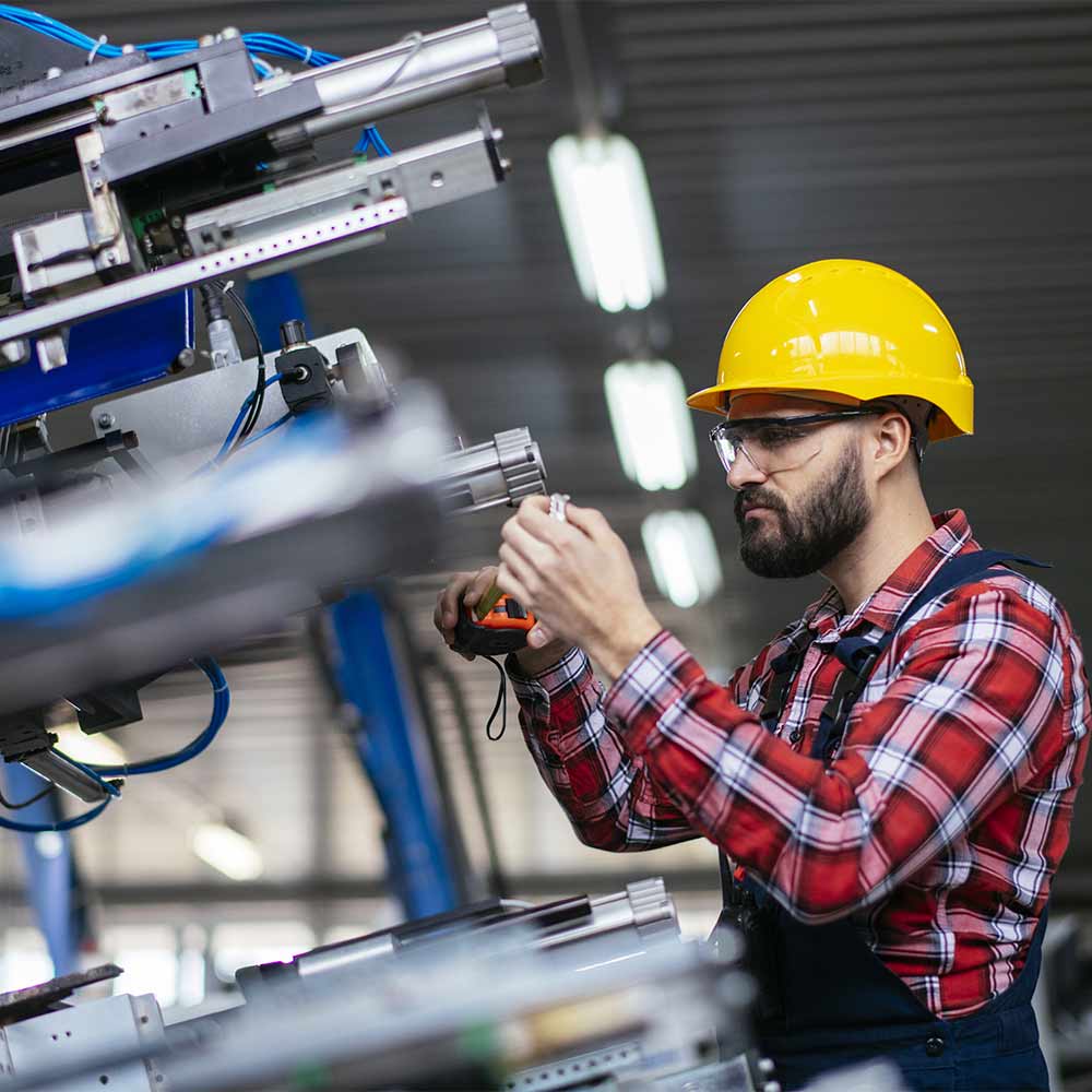 Manual mill worker waring a plaid shirt and personal protection