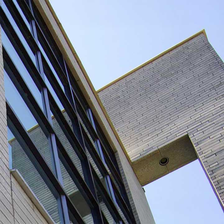 PVue en contre-plongée d'un bâtiment moderne avec des fenêtres à rayures et une section en briques reliée.