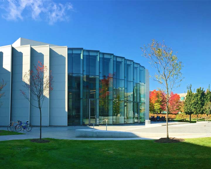 Cours interieur du campus La Cité, on aperçoit des feuillages d'automne aux feuilles rouges et orange, et sur le terrain, on distingue des arbres et des vélos